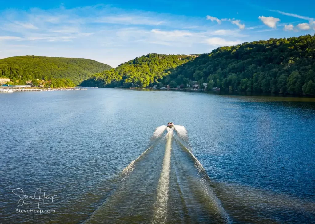 Speedboat sailing down Cheat Lake near Morgantown in West Virginia from aerial drone shot above the water