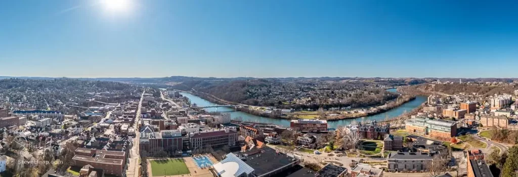 Aerial drone panoramic shot of the downtown campus of WVU in Morgantown West Virginia showing the river in the distance