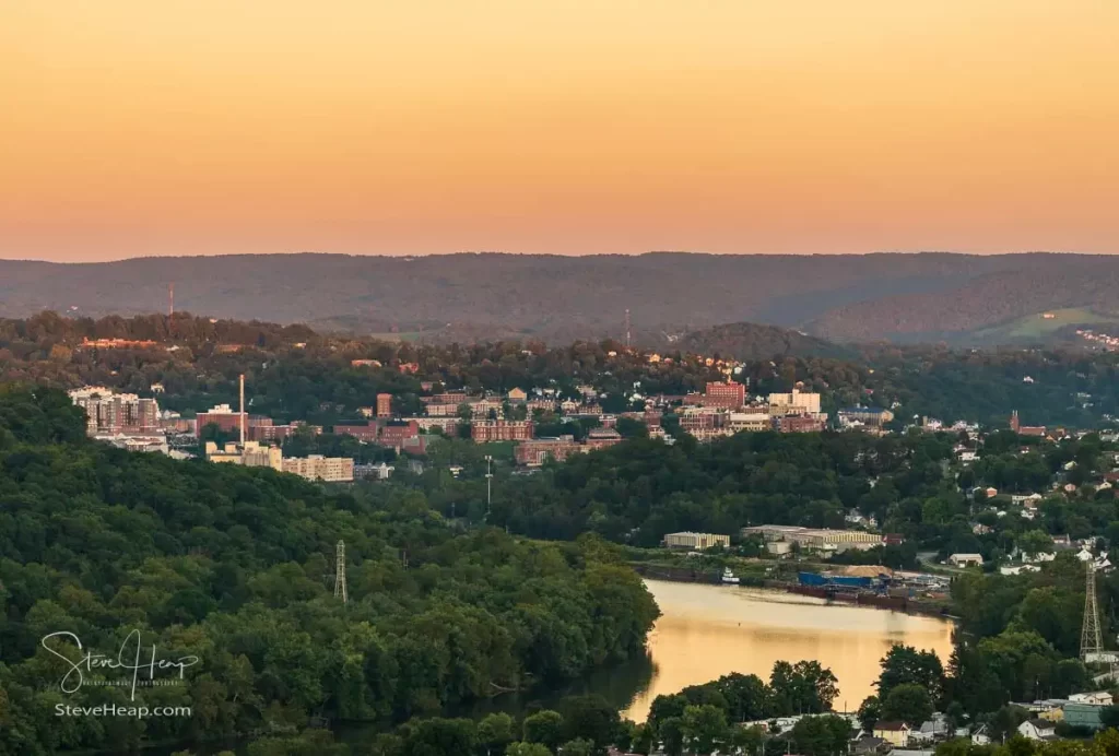 Setting sun illuminates the hills surrounding Morgantown with the downtown campus of WVU above the Monongahela river