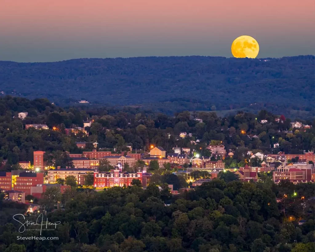 Composite of city of Morgantown in WV as supermoon rises over the town and West Virginia downtown university campus