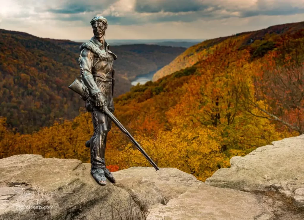 Famous WVU mascot The Mountaineer surveys the dramatic fall colors of the West Virginia mountains.