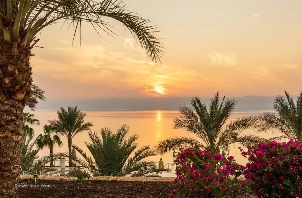 Sunset over the swimming pool and gardens in the Movenpick hotel by the Dead Sea