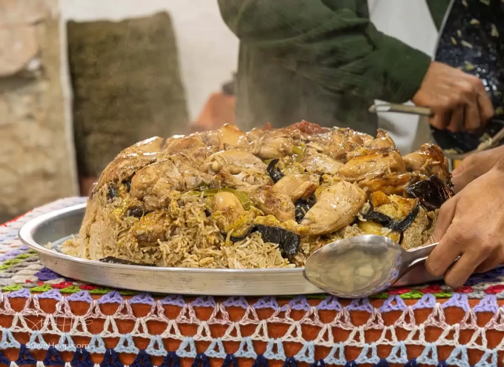 A delicious serving of Maqluba, a traditional Jordanian dish made with layers of rice, chicken, and vegetables, presented at a local restaurant.