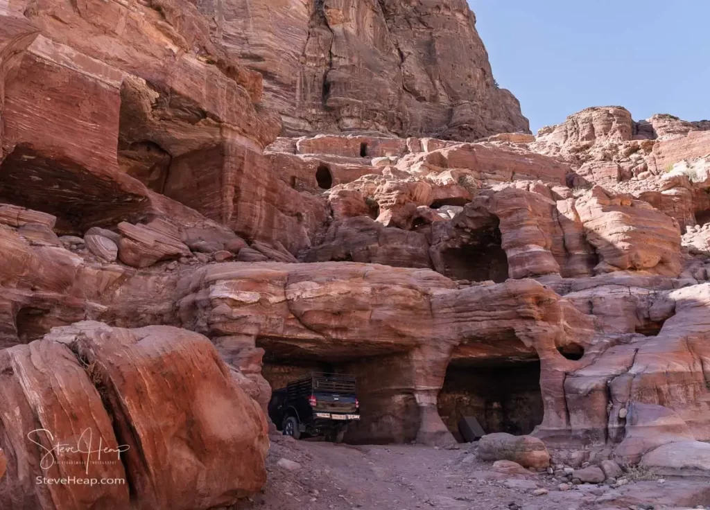 Truck parked in the shade in an excavated cave in the rock face