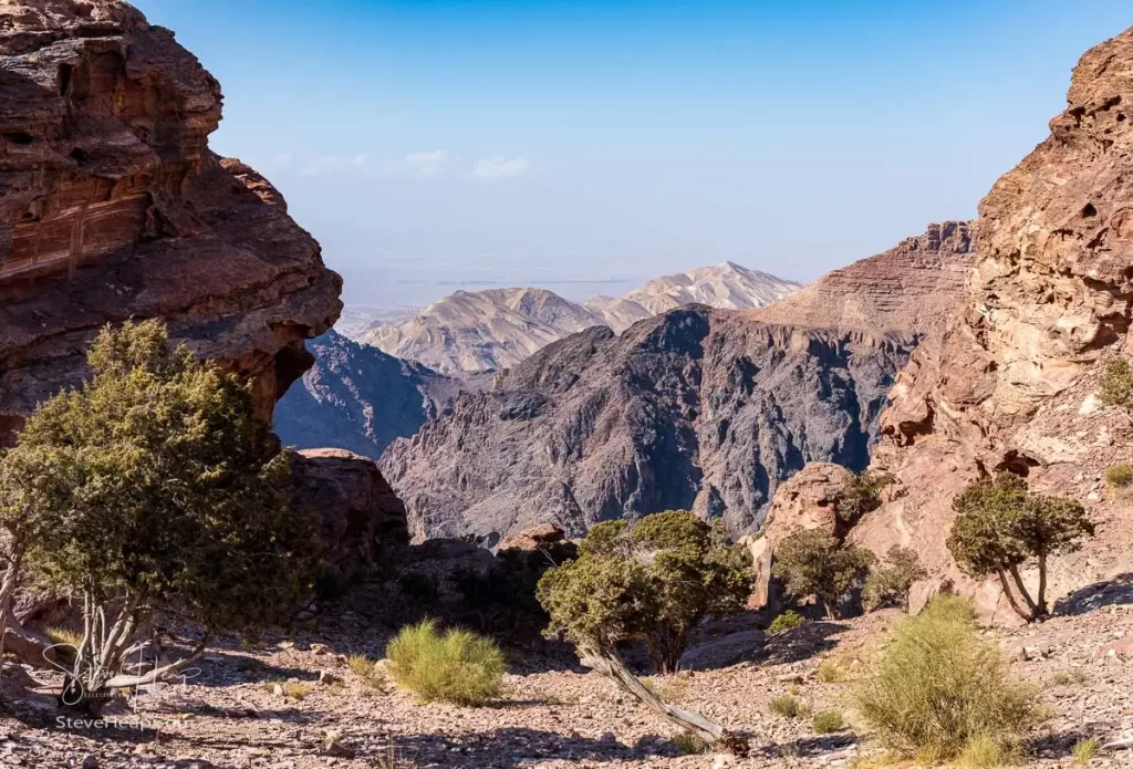 View from the top of the trail to the Monastery of rocky mountain range and gorges with Wadi Araba desert in distance