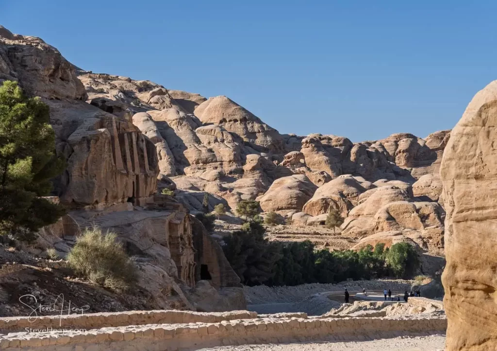 Scenic view along the pathway leading to Petra, showcasing the unique rock formations and tombs carved into the cliffs.