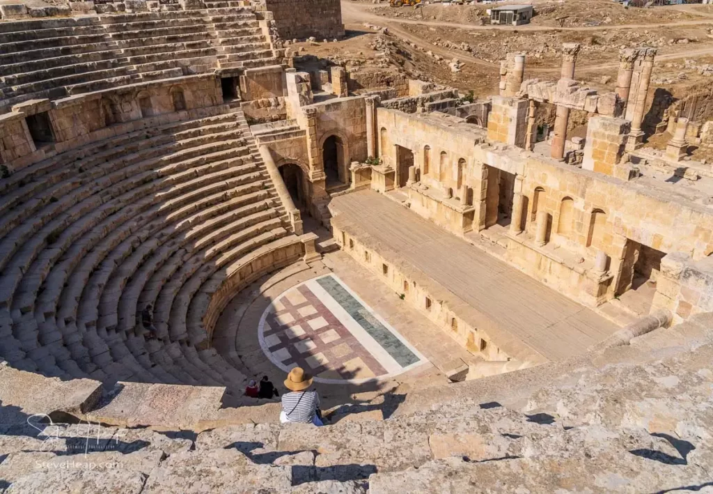 Looking down from the gods towards the brightly colored marble floor of the North Theater in Jerash