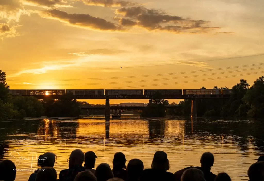 Sunset behind the railroad bridge as an empty freight train crosses the Lady Bird lake. Prints available in my online store