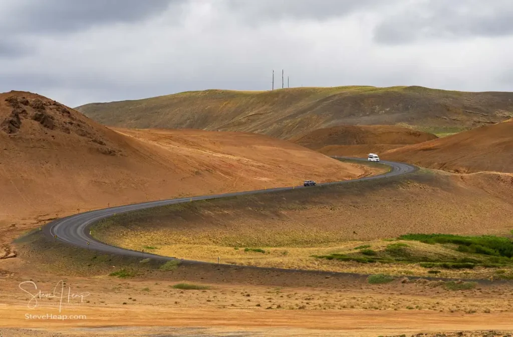 Geothermal activity creates a surreal landscape at Hverir in Namafjall, Iceland with winding roads through mud pots and steam vents