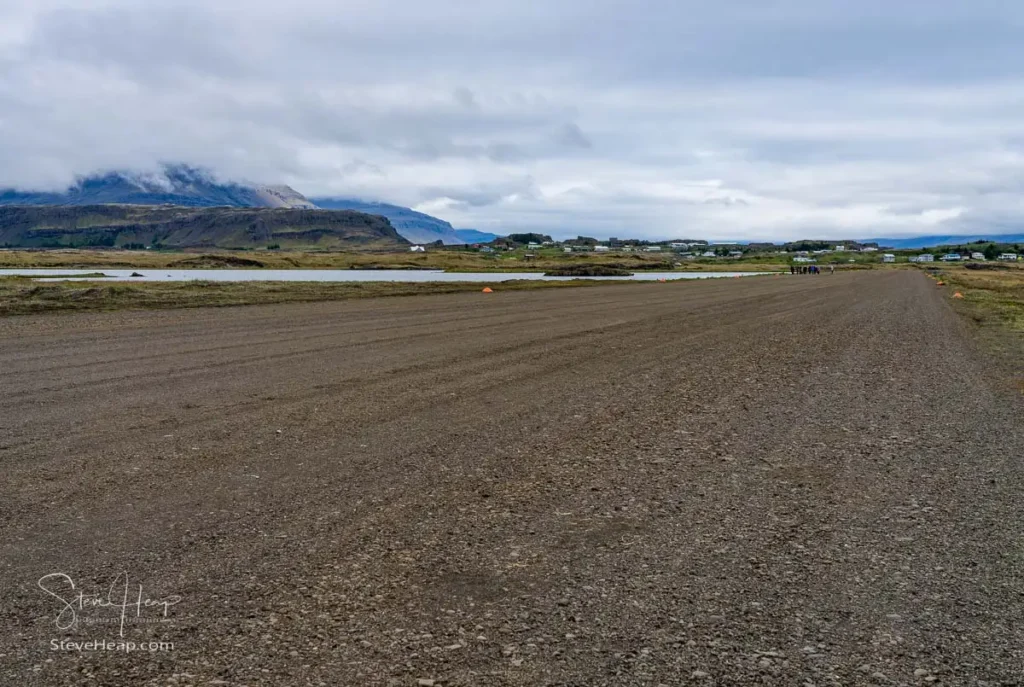 The long runway of what was the town's airport with a Viking tour starting their adventure at the black beaches