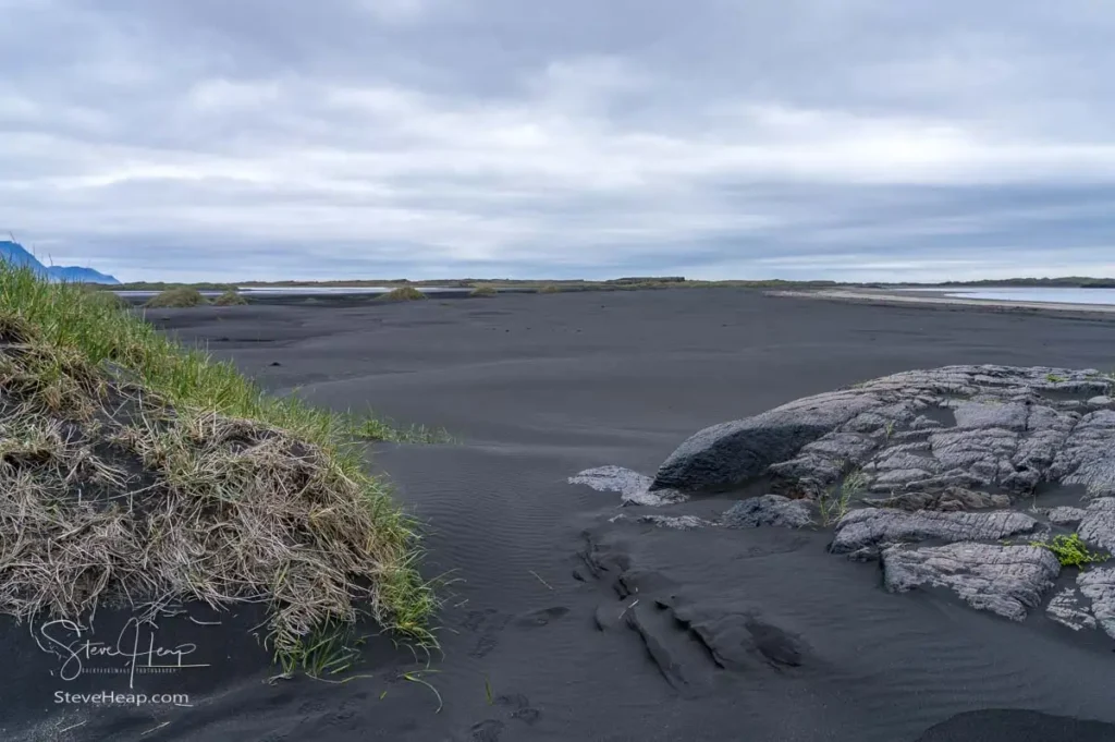 Black sand beach of Bulandsnes in town of Djupivogur in Eastern Iceland with sand dunes framing the view