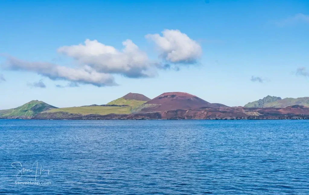 View of Heimaey island off the coast of Iceland from the sea showing the two volcanos