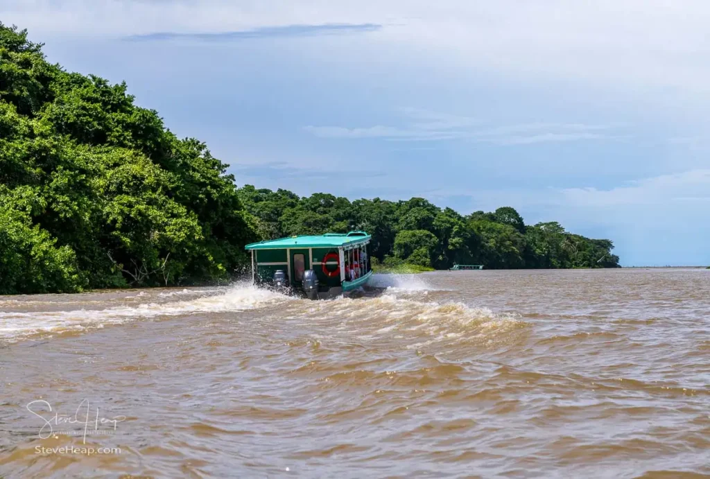 Tour boat headed along the wide canals towards Tortuguero