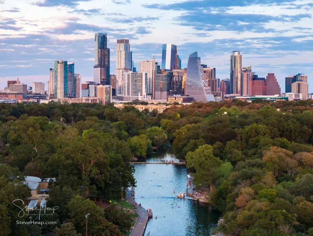 Aerial drone view of the Austin Texas skyline at sunset seen from above the Barton Springs swimming pool on a warm fall evening