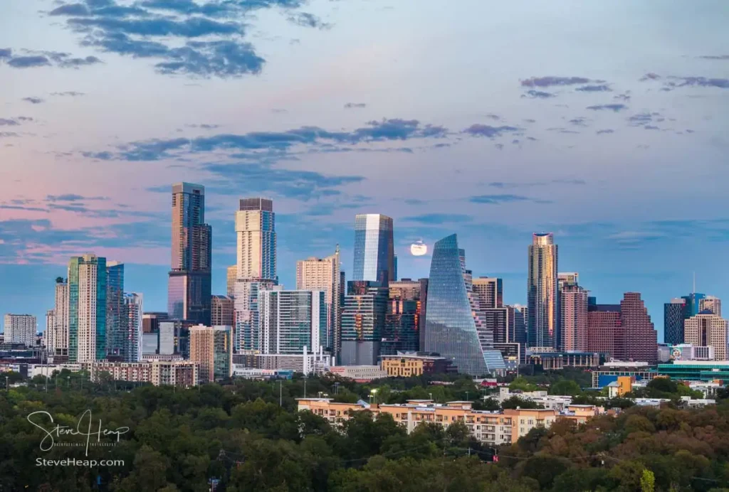 Aerial drone view of the Austin Texas skyline as the full harvest moon is seen rising by the office buildings. Zilker Park in the foreground
