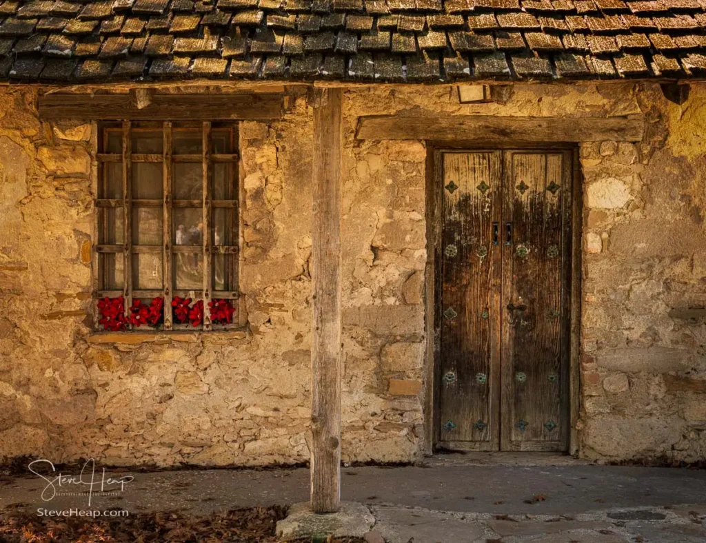 Close-up of an aged wooden door and textured rustic plaster wall at a historic San Antonio San Juan Mission.