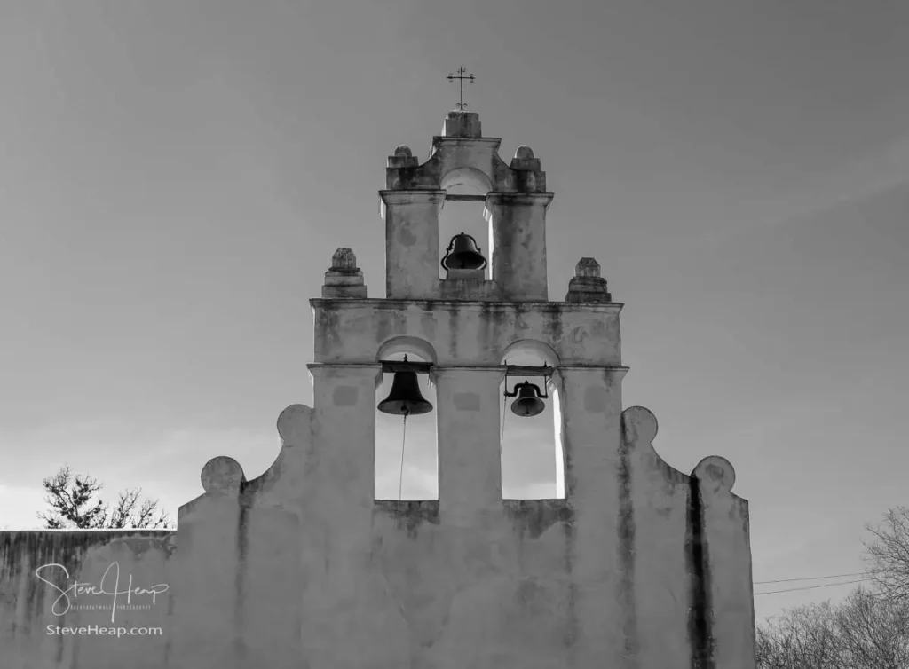 Black and white architectural photography of a Spanish colonial San Juan mission bell tower against a quiet sky in San Antonio, Texas.