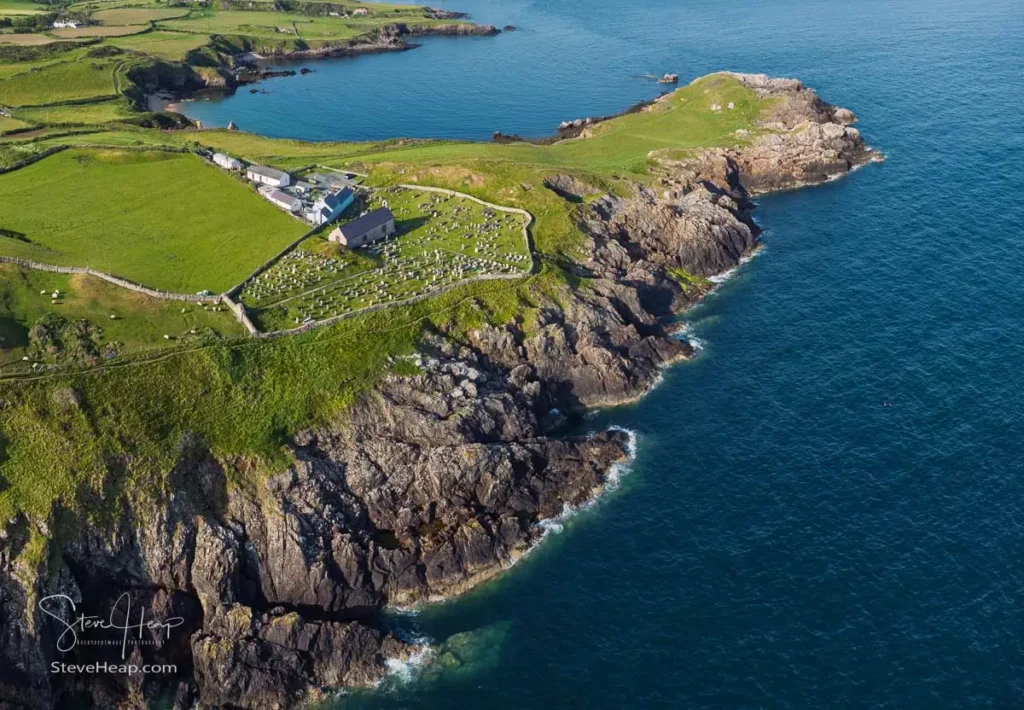 Drone aerial photograph looking down at Eglwys Llanbadrig church on the jagged cliff edge