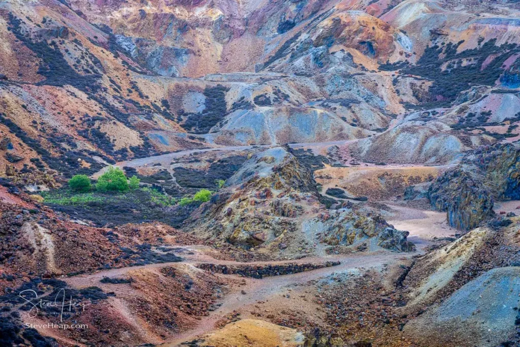 Vast, colorful open-cast copper mine crater with orange and ochre rock faces at Mynydd Parys