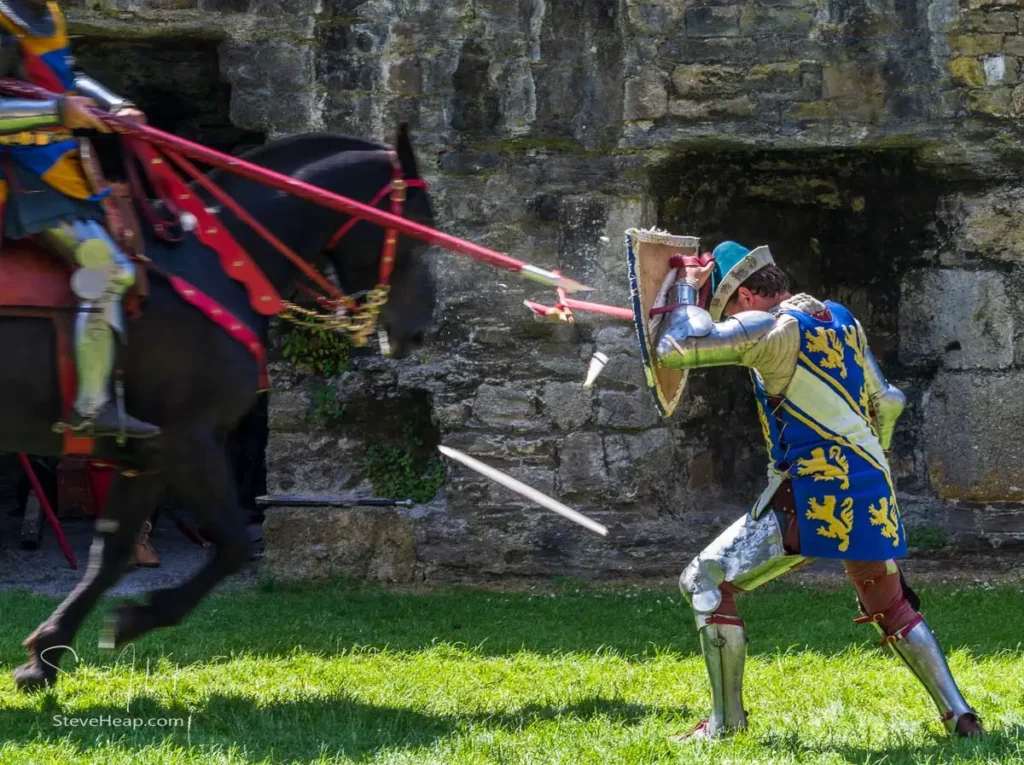 Armored knights performing a jousting demonstration inside Beaumaris Castle