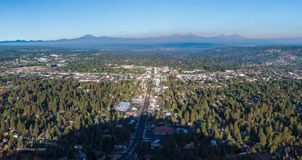 Aerial view of the city of Bend from above Pilot Butte with the shadow of the mountain in the foreground